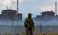 Một lính mặc quân sự in hình quốc kỳ Nga đứng gác trước nhà máy điện hạt nhân Zaporizhzhia ngày 4/8. (Ảnh: Reuters)