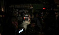 Người dân thành phố Lviv của Ukraine mua đồ trong cửa hàng tối đen vì mất điện ngày 11/10. (Ảnh: Reuters)