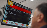 Một người Nhật đang đọc tin cảnh báo về việc Triều Tiên phóng tên lửa. (Ảnh: Reuters)