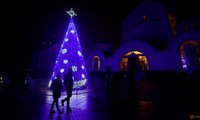Một cây thông Noel trước nhà thờ Cơ đốc ở Ukraine đêm 24/12. (Ảnh: Reuters)