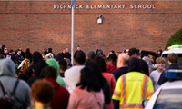 Cảnh sát và người dân đứng bên ngoài trường tiểu học Richneck Sau khi xảy ra vụ tấn công. (Ảnh: AP)