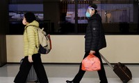 Hành khách bắt chuyến bay ở thành phố Đại Liên, Trung Quốc, ngày 12/1. (Ảnh: Reuters)