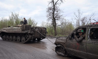 Lính Ukraine dùng xe chiến đấu bộ binh BMP-1 kéo một chiếc ô-tô bị hỏng ở khu vực gần tiền tuyến vùng Donetsk ngày 22/4. (Ảnh: Reuters)