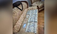 Số đô la Mỹ bị tịch thu được xếp trên chiếc ghế sofa