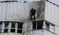 Một nhân viên đang sửa chữa phần hư hỏng của toà nhà ở Mátxcơva sau đợt tấn công ngày 30/5. (Ảnh: Reuters)