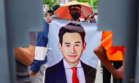 Một người ủng hộ cầm banner in phác hoạ chân dung lãnh đạo đảng Tiến bước Pita Limjaroenrat ở Bangkok ngày 19/7. (Ảnh: Reuters)