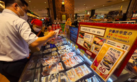 Công nhân xếp hải sản nhập khẩu từ Chile, Pháp và Canada gần tấm bảng và màn hình hướng dẫn cách nấu kiểu Nhật, tại một siêu thị Nhật Bản ở Bắc Kinh ngày 24/8. (Ảnh: AP)