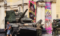  Các thành viên Wagner đứng gác trước một chiếc xe tăng trên đường phố Rostov-on-Don ngày 24.6. (Ảnh: AP)