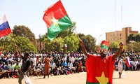 Một người dân Burkina Faso vẫy quốc kỳ ủng hộ chính quyền quân sự và ăn mừng việc đại sứ Pháp rời khỏi nước này. (Ảnh: Reuters)