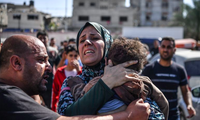 Một người phụ nữ ôm cậu con trai 3 tuổi thiệt mạng sau cuộc không kích xuống thành phố Gaza ngày 26/10. (Ảnh: Getty)