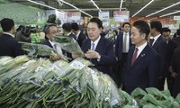 Tổng thống Hàn Quốc Yoon Suk Yeol xem giá hành lá tại một siêu thị ở Seoul ngày 18/3. (Ảnh: AP)