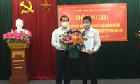 Ông Lý Kim Soi (bìa phải) nhận quyết định và hoa chúc mừng của lãnh đạo tỉnh Lạng Sơn .Ảnh: Duy Chiến