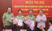 Tân cục trưởng, phó cục trưởng QLTT Lạng Sơn (giữa) nhận quyết định, hoa của lãnh đạo Tổng cục QLTT và lãnh đạo tỉnh Lạng Sơn. Ảnh: Duy Chiến