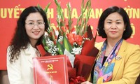 Phó Bí thư Thường trực Thành ủy Nguyễn Thị Tuyến (bên phải) trao Quyết định của Ban Thường vụ Thành ủy và tặng hoa cho bà Nguyễn Thị Huệ. 