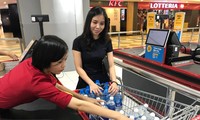Nhân viên siêu thị đang đếm các chai nước loại 1,5 lít trong xe đẩy của một khách hàng