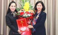 Phó Bí thư Thường trực Thành ủy Hà Nội Nguyễn Thị Tuyến (bên phải) trao quyết định và tặng hoa cho bà Phạm Thị Mỹ Hoa.