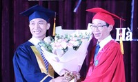 Phạm Việt Dũng (bên trái) nhận hoa chúc mừng của GS.TS Nguyễn Văn Minh, hiệu trưởng trường ĐH Sư phạm Hà Nội trong lễ tốt nghiệp