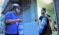 Các tình nguyện viên mang bình oxy đến cho những người cần sử dụng. - Ảnh: Nguyễn Á