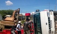Xe tải chở bia bị lật, dân giúp tài xế gom tài sản