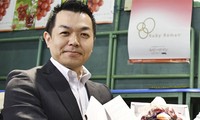 Takashi Hosokawa và chùm nho ông mua với giá 11.000 USD trong phiên đấu giá hôm 9/7. Ảnh: Kyodo 