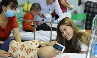 Á hậu 1 Hoa hậu Việt Nam 2018 Bùi Phương Nga vui đùa cùng một bệnh nhi đang điều trị tại Trung tâm Ung thư huyết học nhi khoa