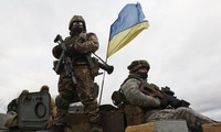 Hình ảnh binh sĩ Ukraine cắm cờ tại một tòa nhà bị đánh bom thuộc làng Blahodatne. Ảnh Reuters. 