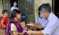 Bác sĩ kiểm tra thân nhiệt của các em nhỏ ở xã Hải Yang