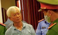 Ông Nguyễn Chiến Thắng (bên trái) nghe cơ quan điều tra đọc lệnh khởi tố bị can tại nhà riêng. Ảnh công an cung cấp