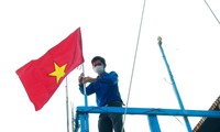 Thanh niên Khánh Hoà gắn cờ Tổ quốc lên tàu cá ngư dân