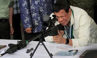 Tổng thống Philippines Rodrigo Duterte ngắm thử súng. Nguồn: CNN.