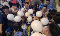 Một nhóm bạn trẻ cùng sử dụng bóng cười tại khu phố Tạ Hiện, Hà Nội.