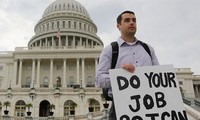 Một nhân viên liên bang Mỹ đứng ngoài tòa nhà Quốc hội giơ tấm biển có dòng chữ: “Hãy làm việc của các ông để tôi có thể làm việc của tôi”, sau khi chính phủ Mỹ bị đóng cửa tạm thời. Ảnh: Larry Downing.