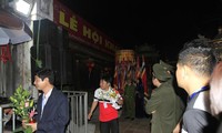 Đại biểu đeo thẻ mang theo lộc từ đền Thiên Trường ra về trước ánh mắt của hàng nghìn du khách. Ảnh: Trường Phong.