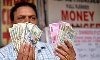 Vì một số lý do, Ấn Độ cũng muốn giảm phụ thuộc vào USD. Trong ảnh: Một người làm nghề đổi tiền ở thủ đô Delhi. Ảnh: Xinhua