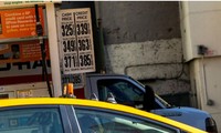  Một tài xế taxi đeo găng tay cao su vào đổ xăng trong khi giá xăng đã giảm do Covid-19 tại New York, Mỹ, ngày 14/3. Ảnh: Getty 