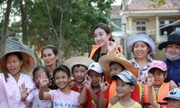 Hoa hậu Đỗ Mỹ Linh trao quà và chụp hình cùng bà con vùng lũ Ảnh: Minh Đức 