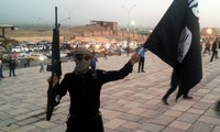 Một tay súng IS vẫy cờ và chĩa súng trên đường phố Mosul (2014)