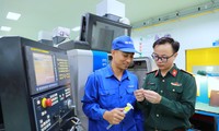 Đại úy Hoàng Đông Đông (bên phải) trao đổi với công nhân Phân xưởng Cơ khí chính xác của Nhà máy Z129 về một chi tiết kỹ thuật