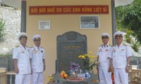Các CCB tàu C235 Lê Duy Mai, Hà Minh Thật, Lâm Quang Tuyến, Nguyễn Hồng Phong trước tấm bia ghi danh các đồng đội liệt sĩ tàu C235 tại Khu di tích lịch sử Quốc gia Hòn Hèo. Ảnh: KIẾN NGHĨA 