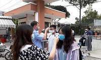 Giáo viên trường THPT chuyên Nguyễn Hữu Huân (quận Thủ Đức, TPHCM) đo thân nhiệt cho học sinh khi dịch COVID-19 tái xuất hiện trong cộng đồng. Ảnh: Huy Thịnh 
