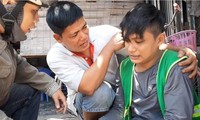 Anh Lê Anh Hựu (ở giữa) hỗ trợ một thanh niên bị tai nạn trên đường. Ảnh: NVCC