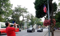Du khách nước ngoài đứng trên đường Đinh Tiên Hoàng chụp ảnh quốc kỳ Việt Nam-Mỹ-Triều Tiên chiều ngày 21/2. ảnh: Như Ý