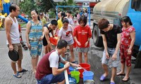 Người dân Linh Đàm, Hà Nội xếp hàng lấy nước sạch từ xe tec nước chở đến. Ảnh: như ý 