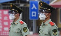 Cảnh sát bán quân sự đeo khẩu trang, kính bảo hộ khi đứng gác tại cổng chợ đầu mối Tân Phát Địa ở Bắc Kinh hôm 13/6. Ảnh: Getty Images 