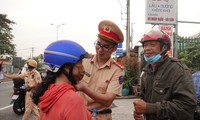 Cảnh sát giao thông phát nước uống, tặng mũ bảo hiểm cho người dân về quê đón Tết 