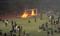 CĐV CLB Persebaya Surabaya đốt cầu môn và biển quảng cáo trên sân Gelora Bung Tomo - Ảnh: Bola