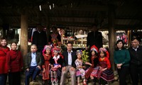 Du khách chụp ảnh kỉ niệm cùng các bé gái người Mông ở chợ phiên Sin Suối Hồ. Ảnh: LỘC LIÊN