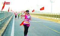 Chị Trần Thị Phượng xúc động khi chạy giữa hai hàng cờ Tổ quốc tại Tiền Phong Marathon Phú Yên 