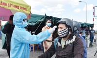 Lực lượng chức năng đo thân nhiệt người vào TPHCM tại chốt kiểm dịch phòng, chống dịch COVID-19 trên quốc lộ 1A Ảnh: Hcmcpv.org.vn