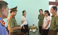 Bị can Nguyễn Thị Hồng Nga (áo trắng bên phải) nghe tống đạt quyết định khởi tố